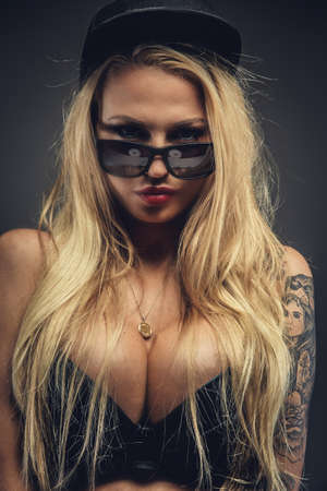 Portrait of sexy blond girl with tattoos. Isolated on grey backgroundの写真素材