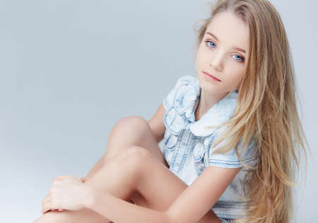Portrait of teenager girl with long blond hair and blue eyes.の写真素材