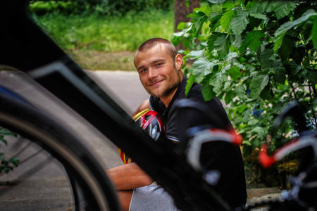 Happy man sitting on steps with sport bycicle in front of him.の写真素材