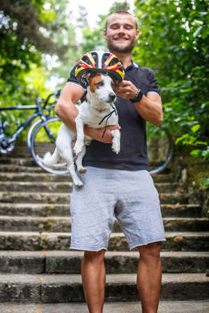Happy man in the forest with his small dog.の写真素材