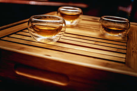 Three glass cups with tea on wooden table.の写真素材