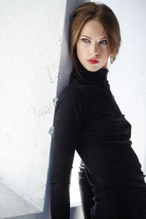 Portrait of brunette slim woman in black clothing.