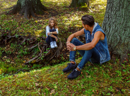 Man sitting under tree and looking at his girlfriend.の写真素材