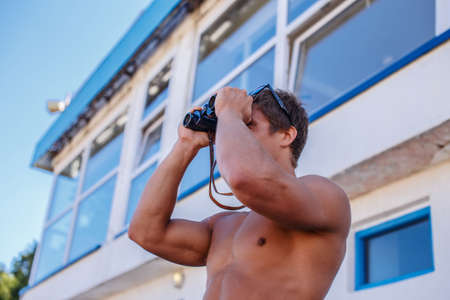 Shirtless muscular rescue looking through binocular.の写真素材