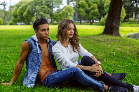 Man with woman relaxing on grass in a park.の写真素材