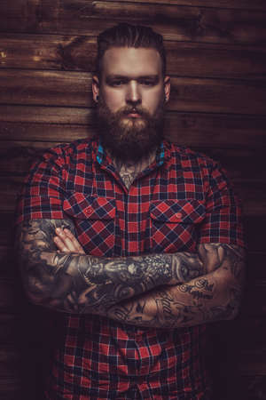 Portrait of serious brutal man with beard and tattooes. Crossed arms.の写真素材