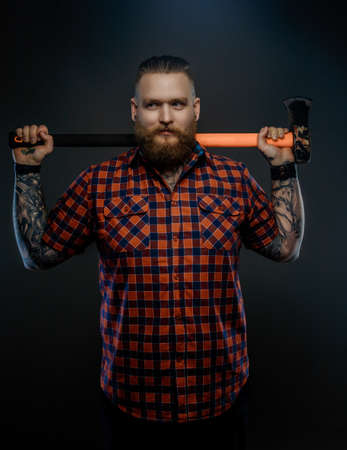Serious man in red t shirt holding big axe. Isolated on grey background.の写真素材