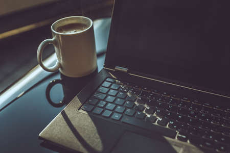 Morning cup of coffee and working space with laptop.の写真素材