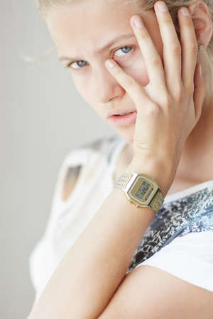Portrait of blond woman with arm near her face.の写真素材