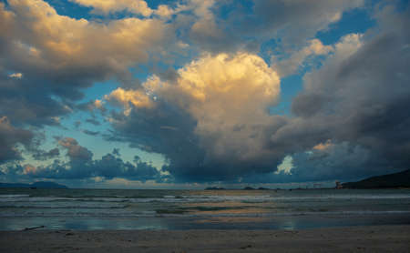 Seashore and blue sky with colorful clouds.