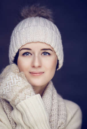 Portrait of cute brunette woman in white pulover and winter hat.の写真素材