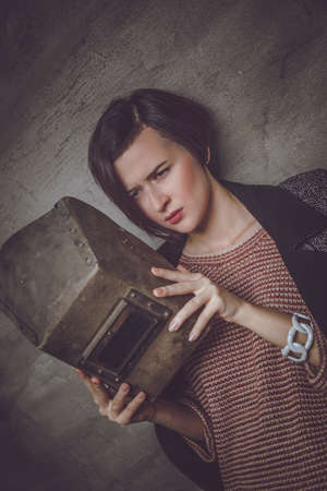 Fashionable girl holds welder mask.