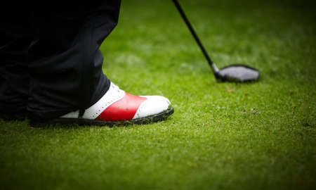 Golf player's legs on grass field.の写真素材