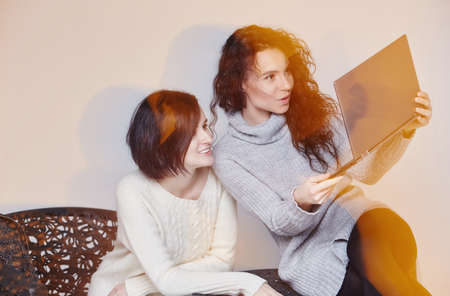 Two brunette girls looking at laptop.の写真素材