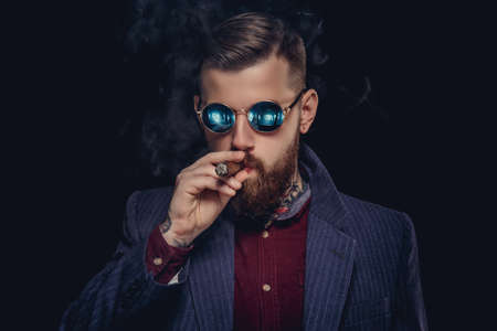 Bearded guy in sunglasses smocking cigar.の写真素材