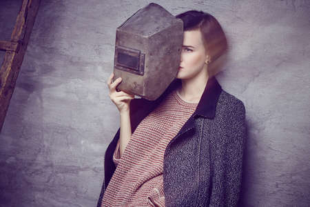 A woman in overall and welder helmet.の写真素材