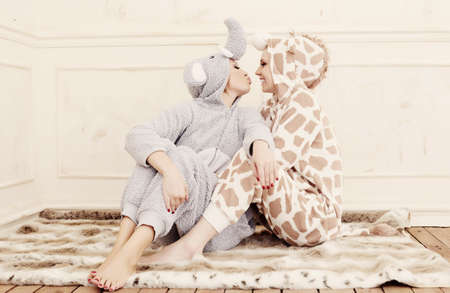 Two women in pajamas kissing each other.の写真素材