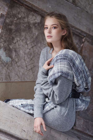 Slim woman in a long grey dress posing.の写真素材