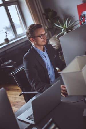 A man in a grey suit working on computer in the office.の写真素材