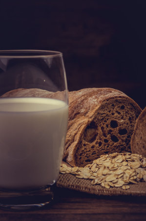 Milk and brown bread on the table.