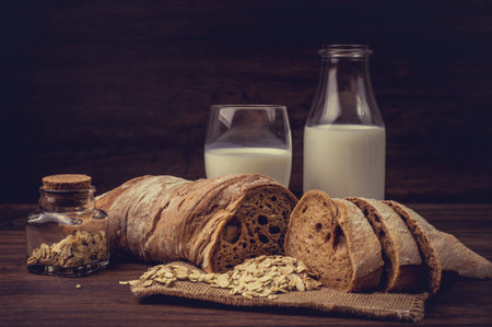 Brown bread and a bottle of a milk on the table.