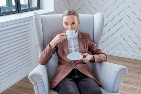 Modern woman drinking morning coffe at home.