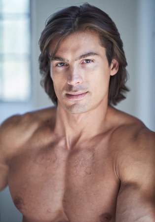 Portrait of shirtless muscular male in natural light.