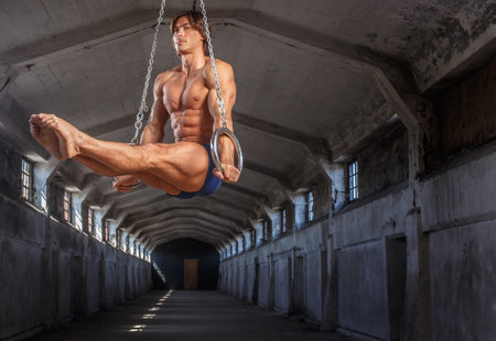 Man workouts in the air with gimnastic rings.