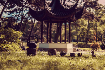 Chinese tea ritual in summer park with traditional chinese arbour on background.の写真素材