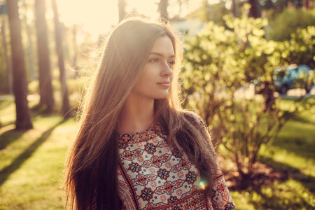 Portrait of long hair female in a park on sunny summer day.の写真素材