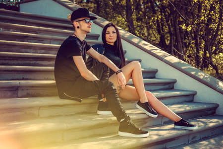 Casual neordinary couple relaxing on steps in a park.の写真素材