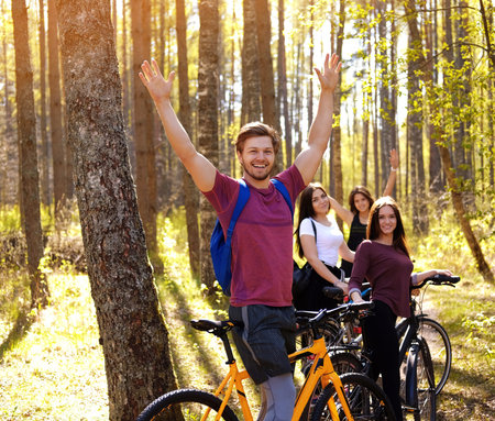 Group of friends relaxing in a park after bicycle riding.