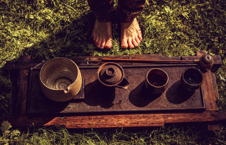 Human barefoot and traditional chinese tea table with cups and teapot.の写真素材