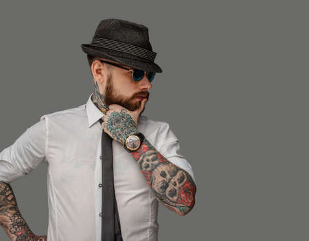 Tattooed bearded man in white shirt isolated on grey background.の写真素材
