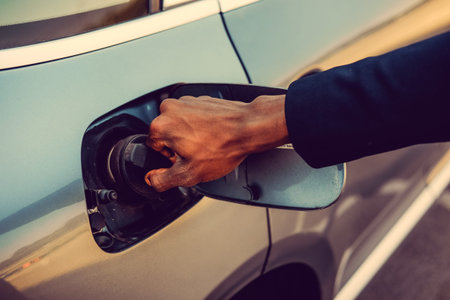 Black man's arm near car's gas tank.の写真素材