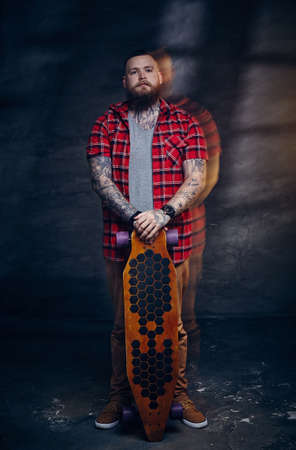 Full body portrait of bearded skateboarder with longboard.の写真素材