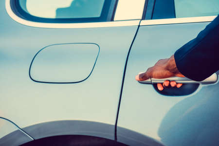 Black man's arm near car's gas tank.の写真素材