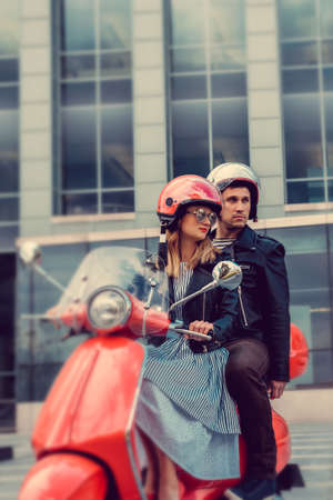 Casual couple riding a moto scooter in downtown.の写真素材