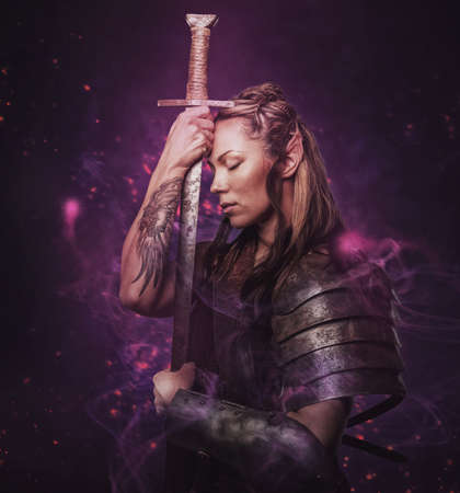 Elf woman in armor holding sword. Isolated on greyの写真素材