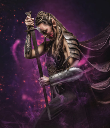 Elf woman in armor holding sword. Isolated on greyの写真素材