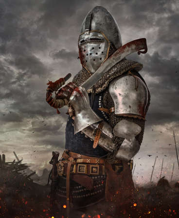 Knight with sword in battlefield with dark clouds on background.の写真素材