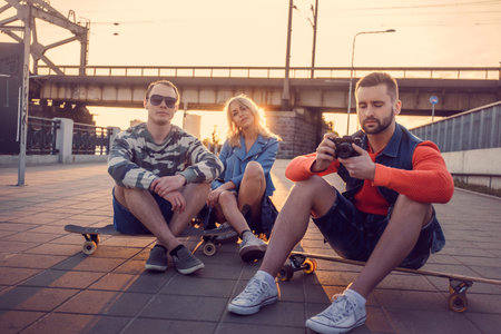 Casual longboarders sits on ther skates in sunrise.