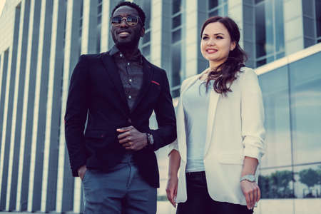 Modern black man and caucasian woman in a town.の写真素材