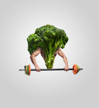 Broccoli with muscular man's hands and barbell.の写真素材