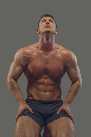 Athletic shirtless male in a black panties looking up.の写真素材