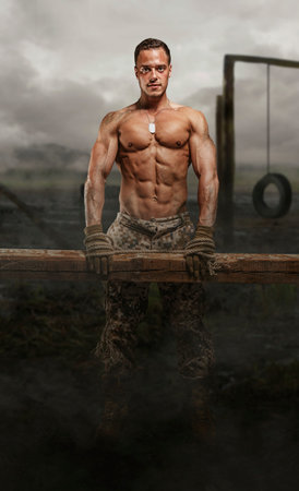 Shirtless soldier with wooden timber in a swampland.