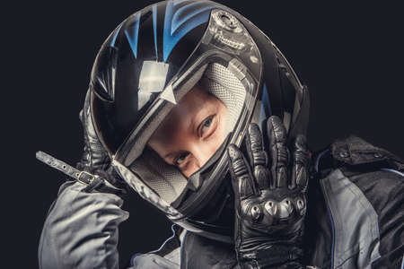 Portrait of female in motorcycle safety costume and black helmet.の写真素材