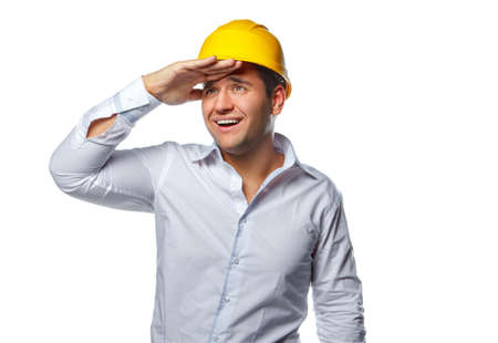 Portrait of positive worker male in yellow safe helmet isolated on a white background.の写真素材