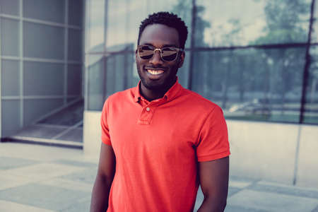 Portrait of smiling african american male in a red polo t shirt.の写真素材