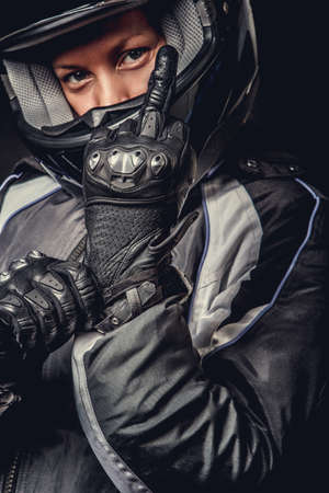 Portrait of female in motorcycle safety costume and black helmet.の写真素材